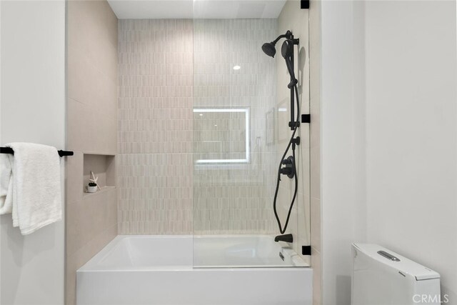 bathroom featuring toilet and tiled shower / bath combo