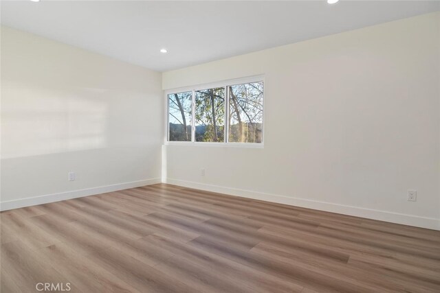 unfurnished room with hardwood / wood-style floors