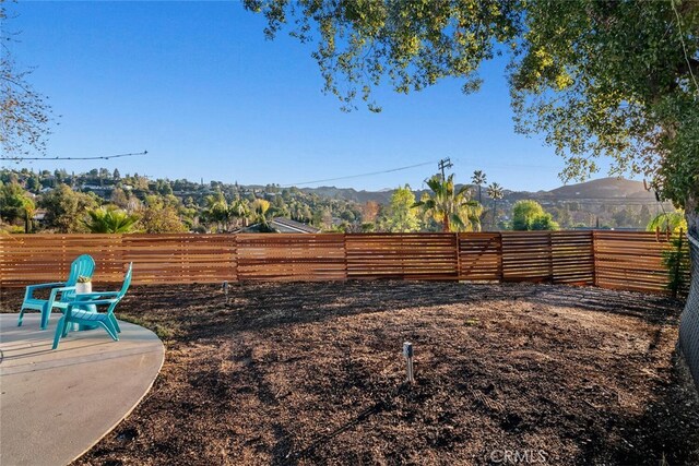 view of yard with a mountain view and a patio