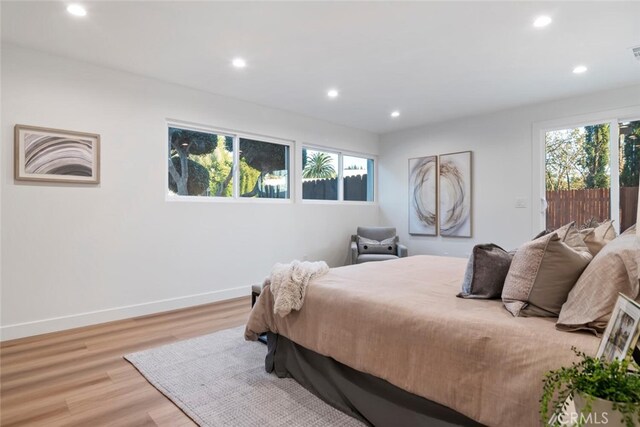 bedroom featuring multiple windows and light hardwood / wood-style flooring