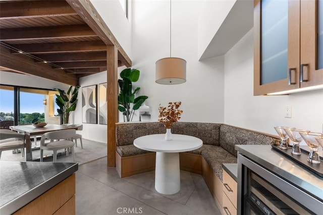 bathroom featuring concrete floors, wooden ceiling, breakfast area, and beamed ceiling