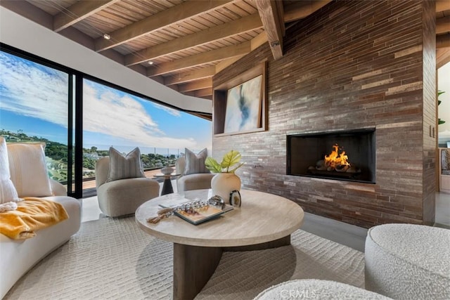 sunroom / solarium featuring beam ceiling, a fireplace, and wooden ceiling