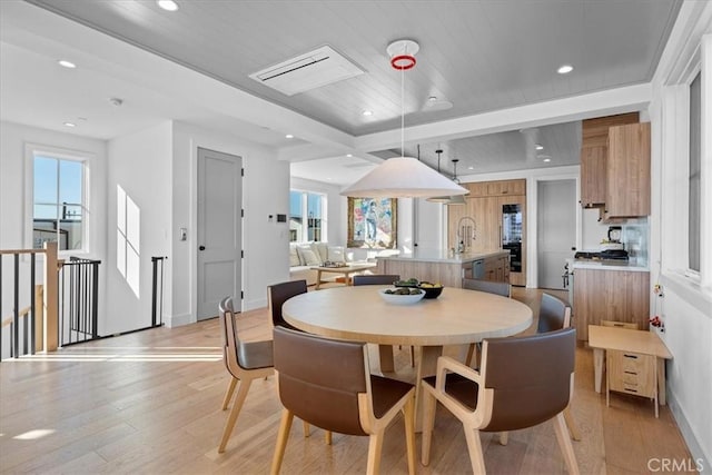 dining room featuring wood ceiling, light hardwood / wood-style flooring, and sink