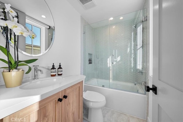 full bathroom with bath / shower combo with glass door, toilet, vanity, and tile patterned flooring