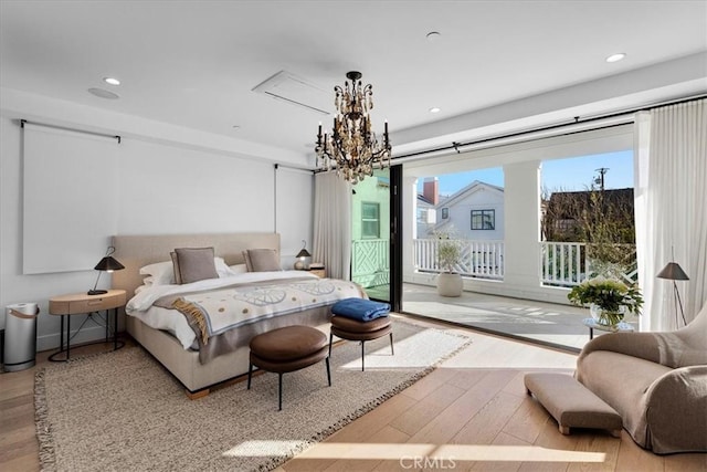 bedroom with access to outside, a notable chandelier, and hardwood / wood-style flooring