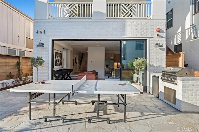 view of patio / terrace with a balcony, a grill, and area for grilling