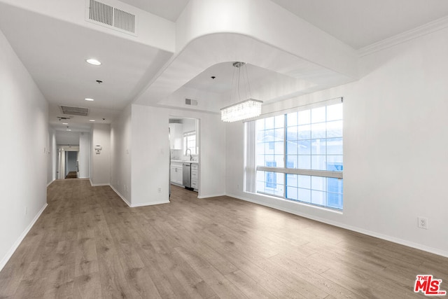 unfurnished living room featuring crown molding and light hardwood / wood-style flooring