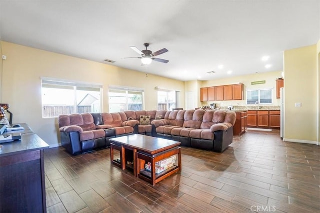 living room featuring ceiling fan and sink