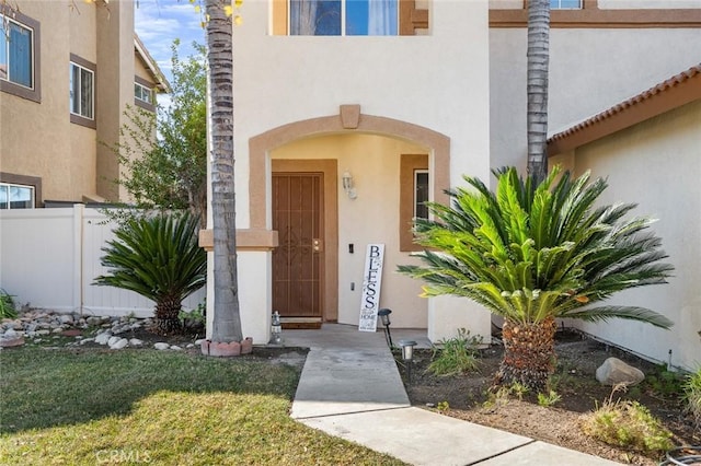 property entrance featuring a lawn