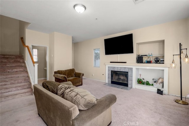 living room with light carpet and a tiled fireplace