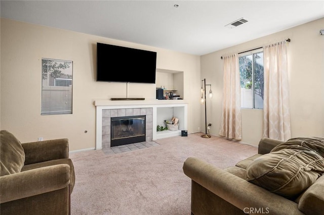 carpeted living room with a tiled fireplace