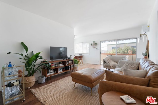 living room featuring a wall unit AC and hardwood / wood-style flooring