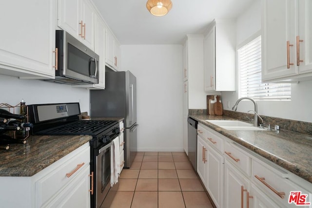 kitchen featuring light tile patterned flooring, stainless steel appliances, white cabinetry, and sink