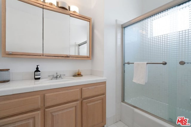 bathroom with sink and enclosed tub / shower combo