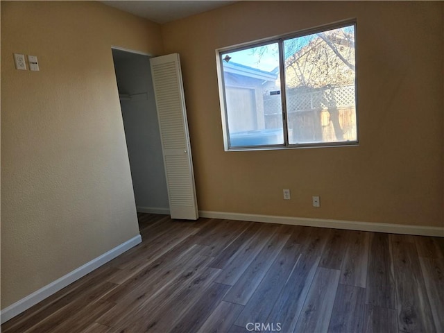 unfurnished bedroom featuring a closet and dark hardwood / wood-style flooring