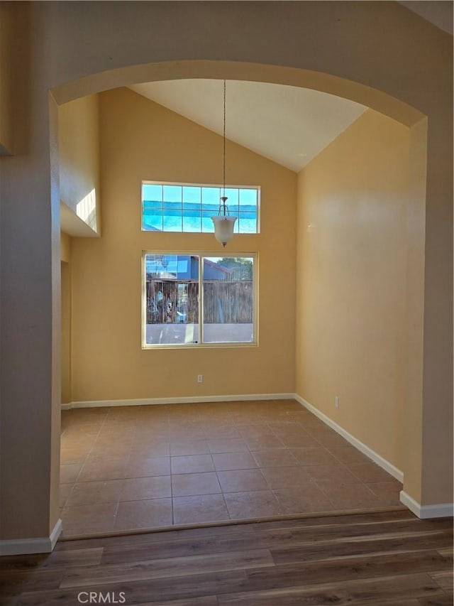 unfurnished dining area with vaulted ceiling and hardwood / wood-style flooring