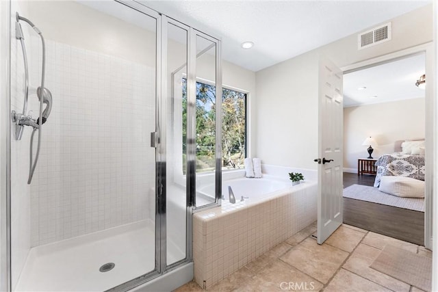 bathroom featuring separate shower and tub