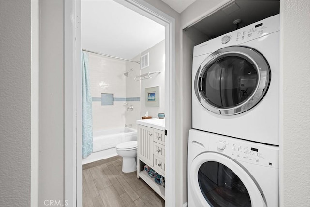 laundry area featuring stacked washer / dryer