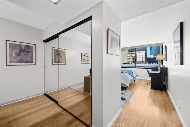 hallway with a textured ceiling and hardwood / wood-style flooring