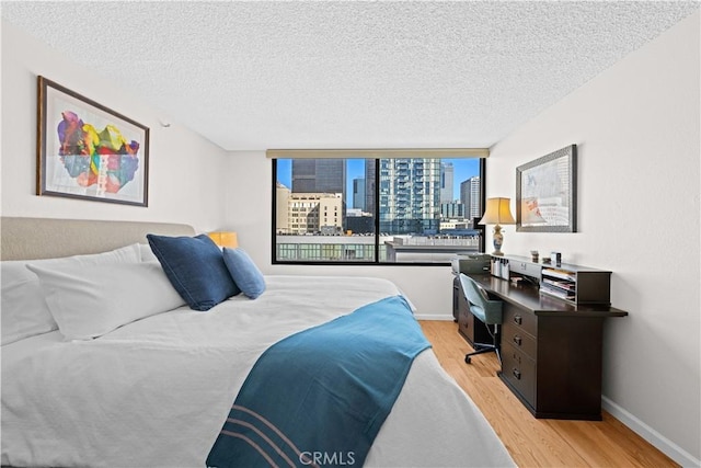 bedroom with a textured ceiling and light hardwood / wood-style flooring