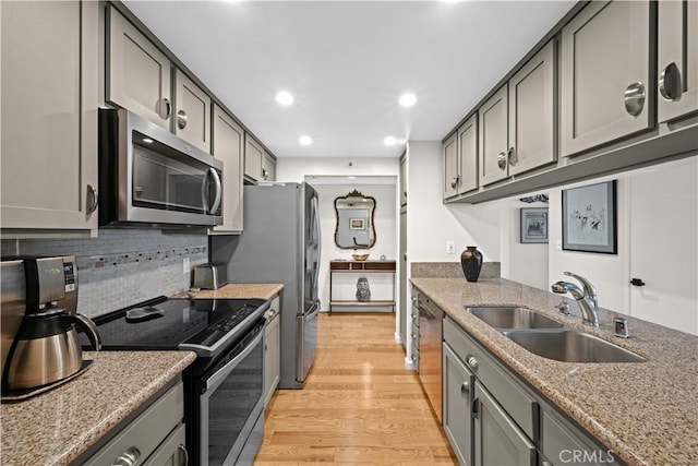 kitchen with gray cabinets, appliances with stainless steel finishes, light hardwood / wood-style flooring, and sink