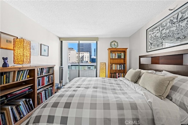 bedroom with a wall of windows and a textured ceiling