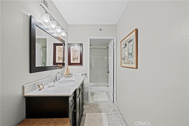 bathroom featuring a textured ceiling, tile patterned floors, vanity, toilet, and walk in shower