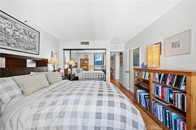 bedroom with hardwood / wood-style floors and a textured ceiling