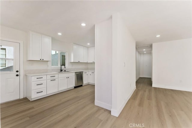 kitchen with white cabinetry, light hardwood / wood-style floors, stainless steel dishwasher, and sink