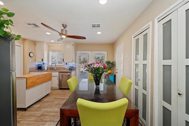 dining area with ceiling fan, sink, and french doors