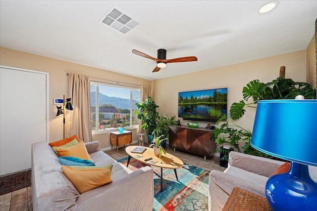 living room with ceiling fan and light hardwood / wood-style flooring