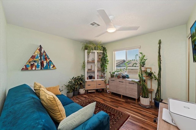 living area featuring ceiling fan and dark hardwood / wood-style flooring