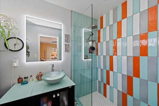 bathroom featuring vanity and tiled shower