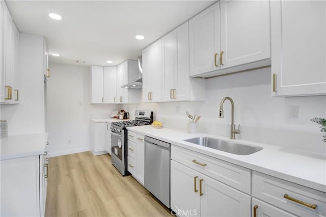 kitchen featuring light hardwood / wood-style floors, white cabinets, appliances with stainless steel finishes, and sink