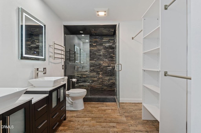 bathroom with toilet, a shower with door, hardwood / wood-style floors, and vanity