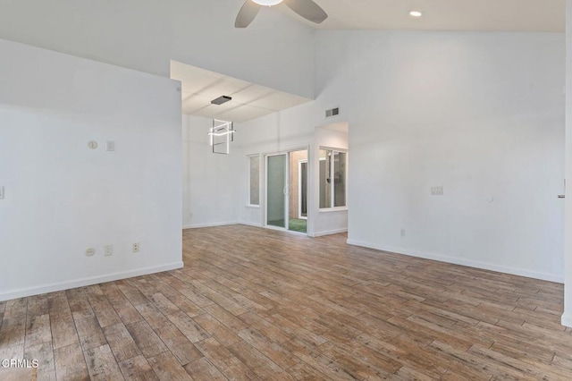 empty room with ceiling fan, light wood-type flooring, and high vaulted ceiling