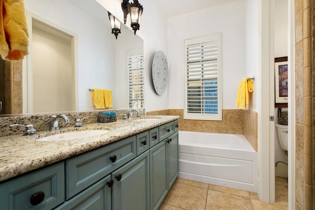 bathroom featuring toilet, tile patterned flooring, a tub to relax in, and vanity