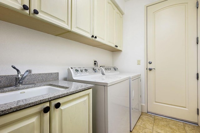 laundry area featuring cabinets, separate washer and dryer, light tile patterned flooring, and sink