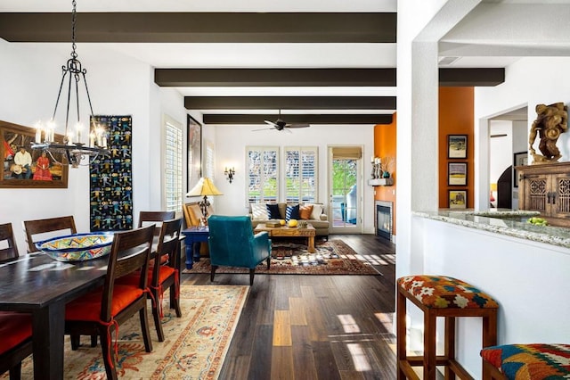 dining space with beam ceiling, dark hardwood / wood-style flooring, and ceiling fan with notable chandelier