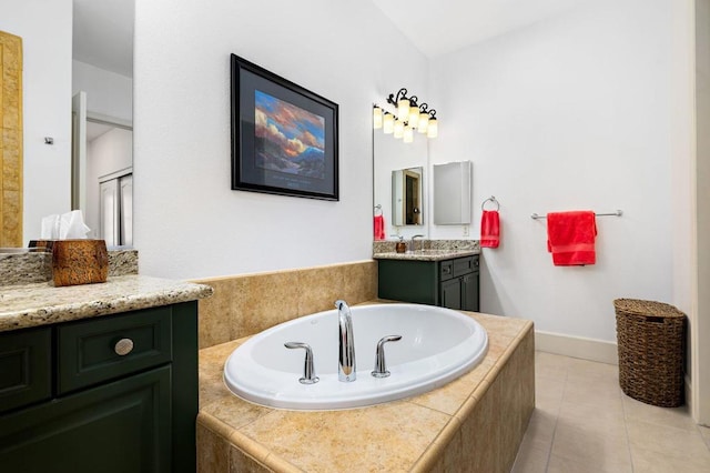 bathroom featuring tiled tub, vanity, and tile patterned flooring