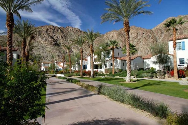 view of home's community with a mountain view and a lawn