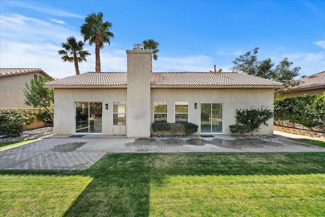 rear view of property with a patio and a lawn