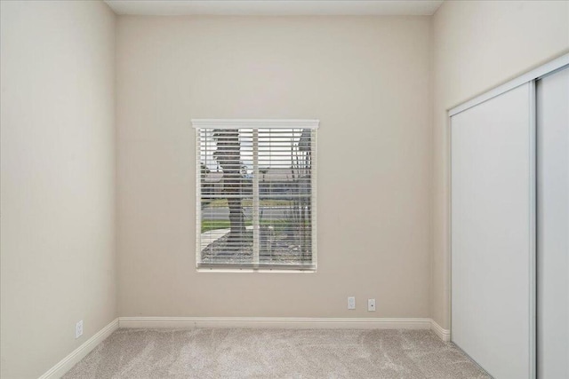 unfurnished room featuring light colored carpet