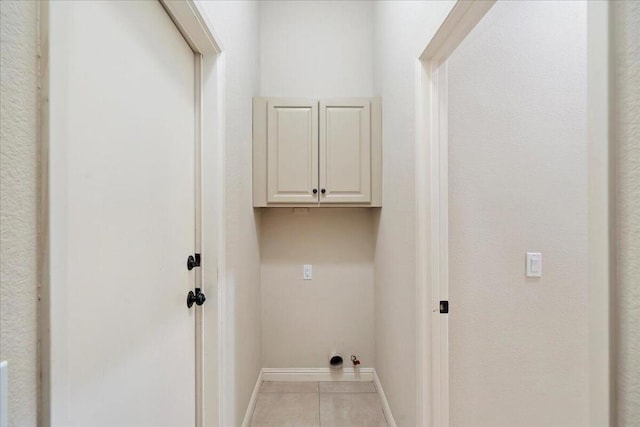 laundry room with cabinets and light tile patterned floors