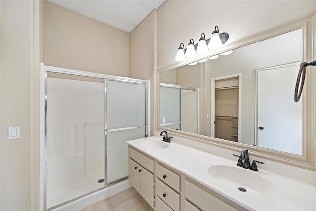 bathroom with tile patterned floors, a shower with door, and vanity