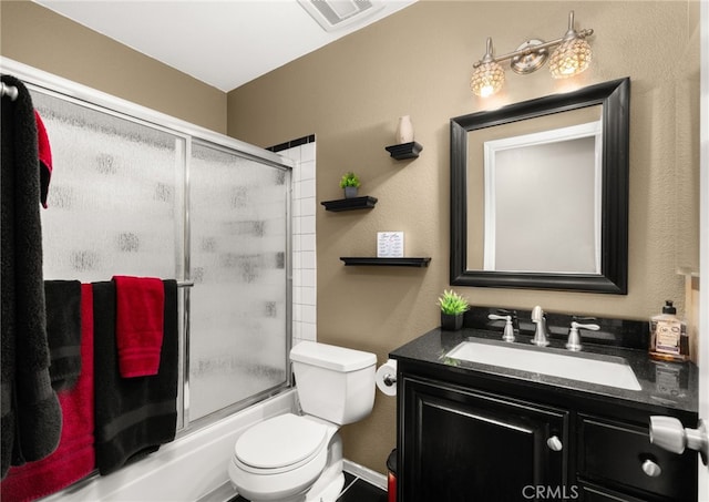 full bathroom with combined bath / shower with glass door, vanity, and toilet