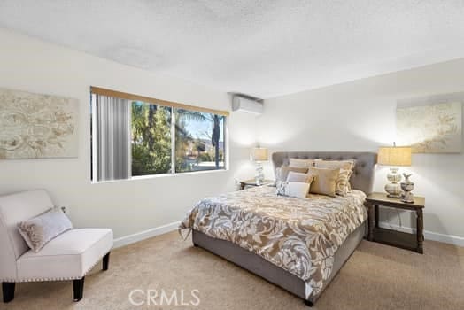 carpeted bedroom with an AC wall unit