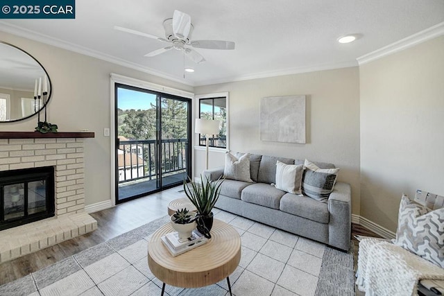 living room featuring a brick fireplace, ornamental molding, and ceiling fan