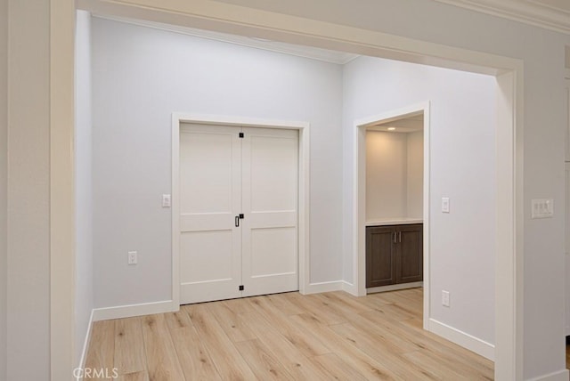 hall featuring ornamental molding and light wood-type flooring