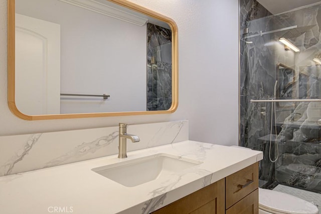 bathroom featuring toilet, ornamental molding, a shower with shower door, and vanity